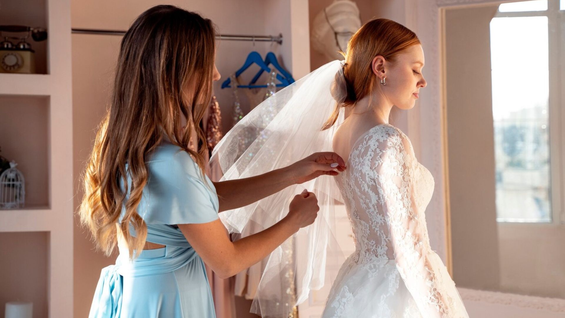 bride and bridal lady fitting their wedding outfits